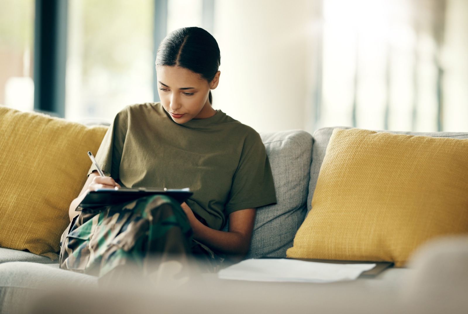 A woman writing in a notebook at home
