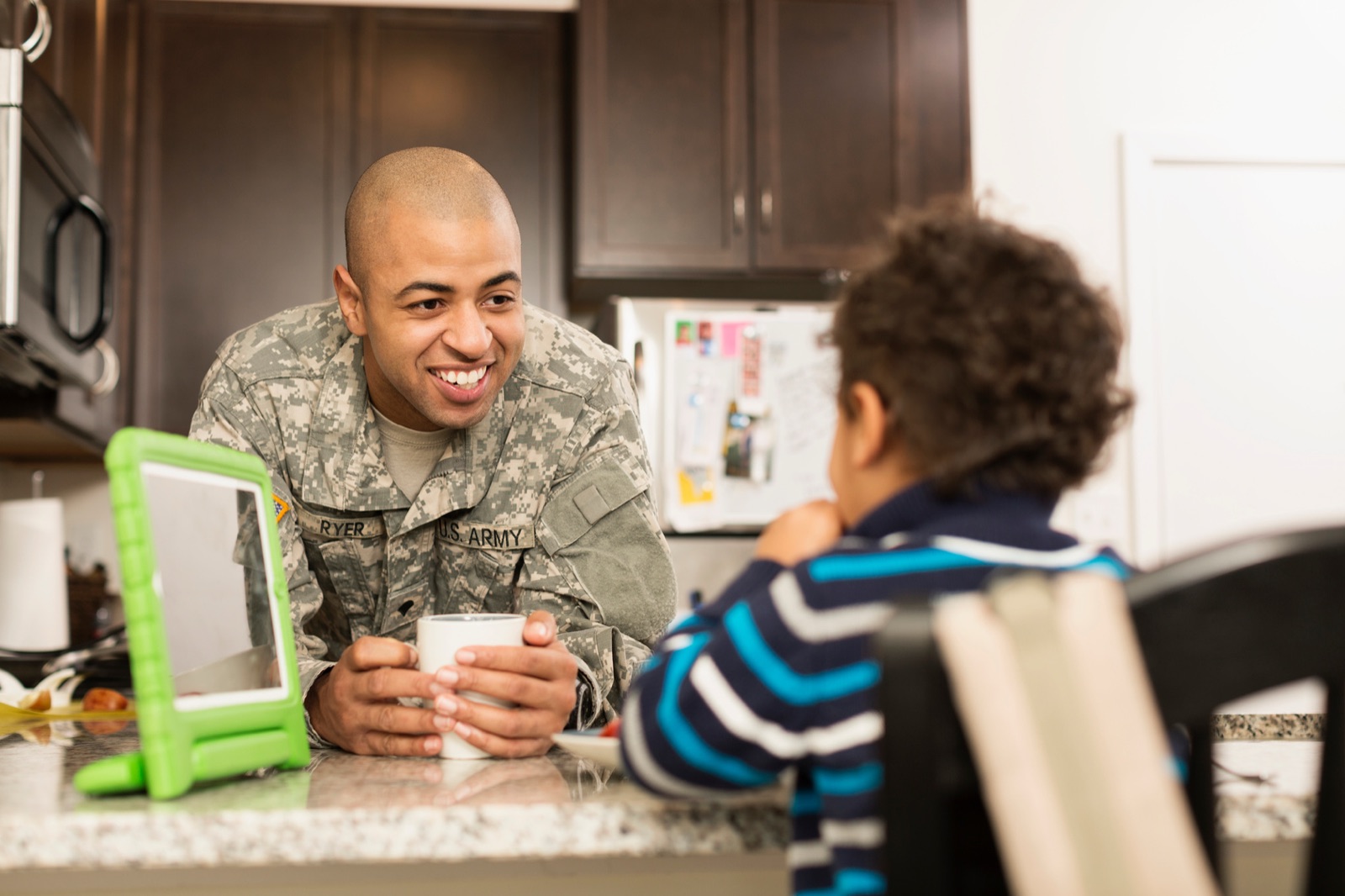 A service member talking with his child at home